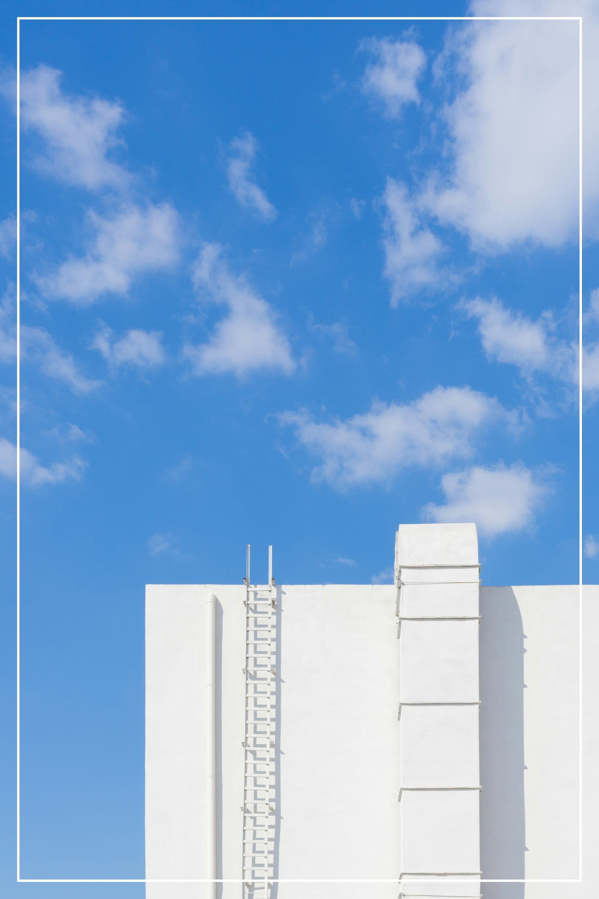A tall white building with a blue sky in the background